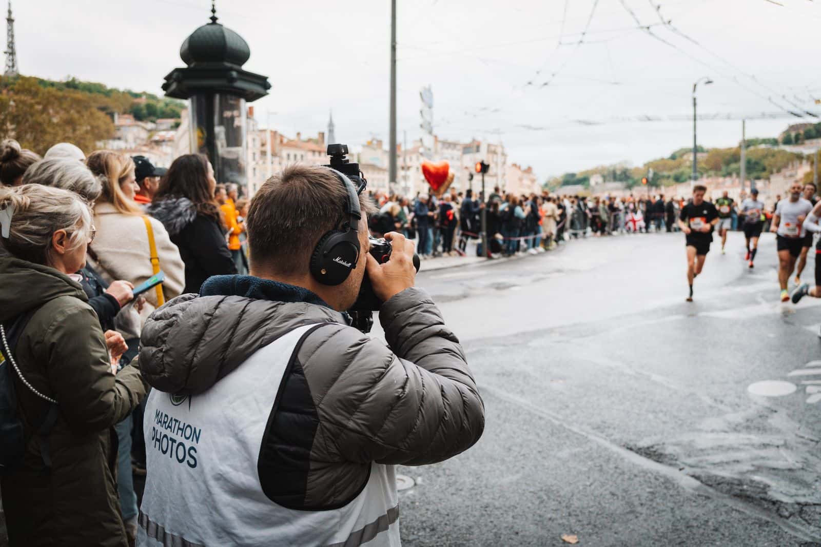 Race photographer capturing runners from the course edge