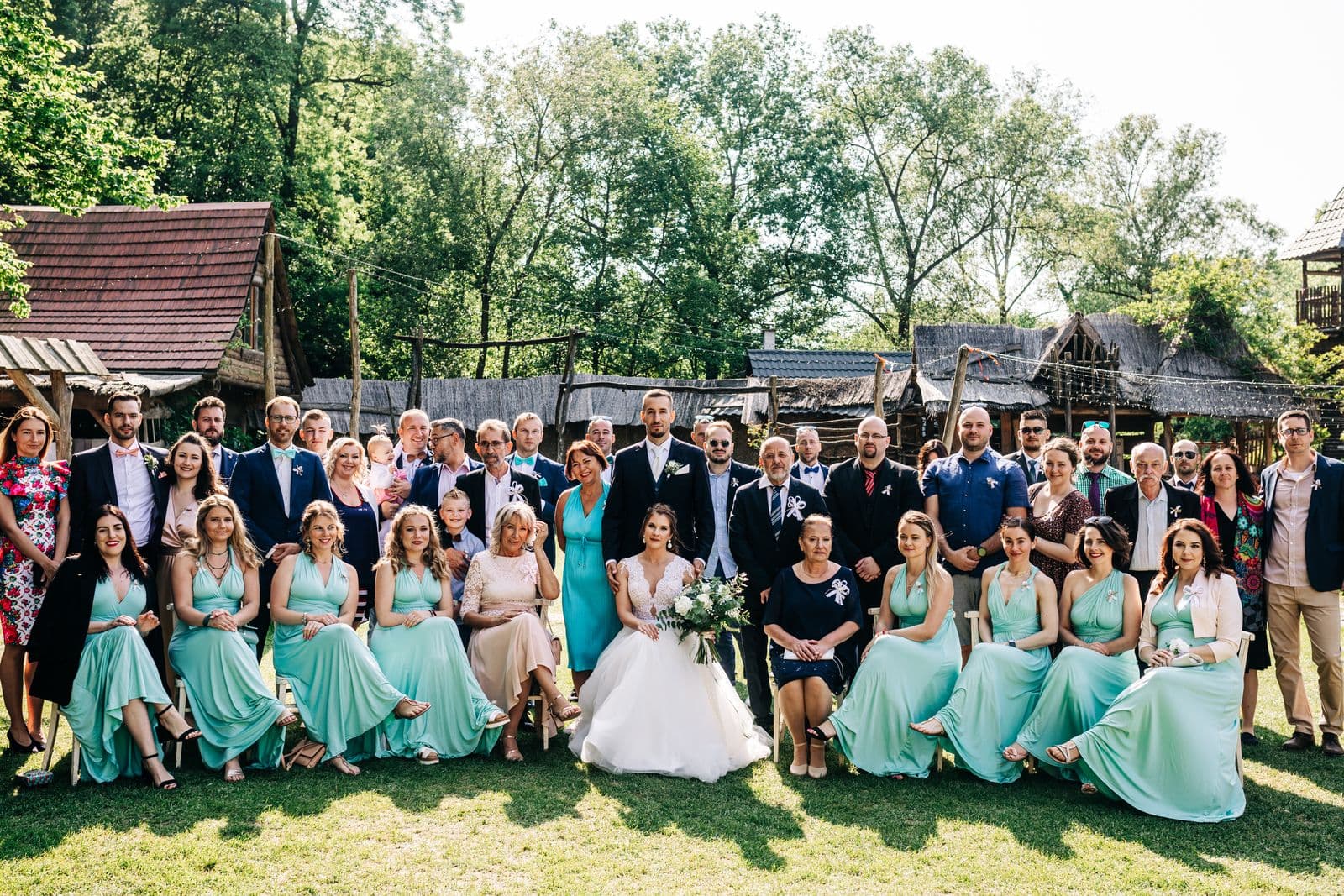 Newlyweds posing with a large group of wedding guests