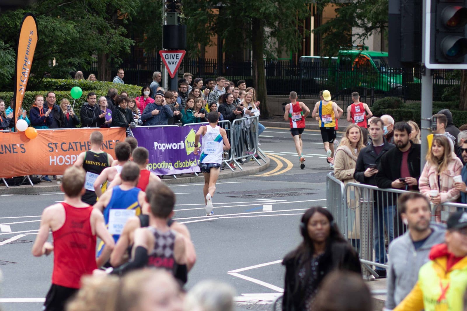 Runners and spectators moving through a city marathon route